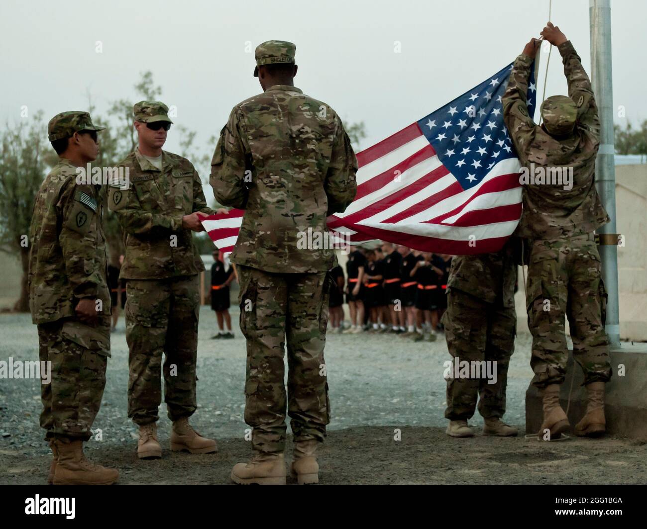 Soldaten der 3. Staffel, des 4. Kavallerieregiments, der 3. Brigade, der 25. Infanteriedivision heben am 11. September die Flagge auf der Forward Operative Base Shinwar, Afghanistan, zu Beginn einer Gedenkfeier 9/11. Die Gedenkfeier folgt den Spuren des gefallenen New Yorker Feuerwehrmörders Stephen Siller als Hommage an sein Engagement im Dienst. Stockfoto