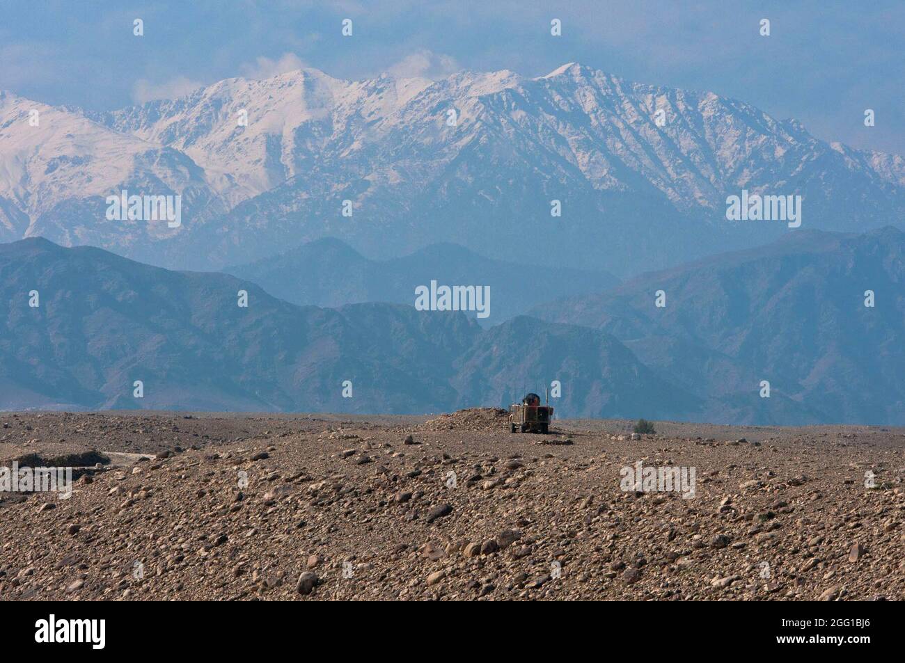 NANGARHAR PROVINZ, Afghanistan – die Berge von Tora Bora ragen über einem eineinigen US-Minenresistenten Hinterhalt geschützten Fahrzeug, während es vor dem Kampfposten Achin am 5. November patrouilliert. (USA Armee-Foto von SPC. Ken Scar, 7. MPAD) Stockfoto