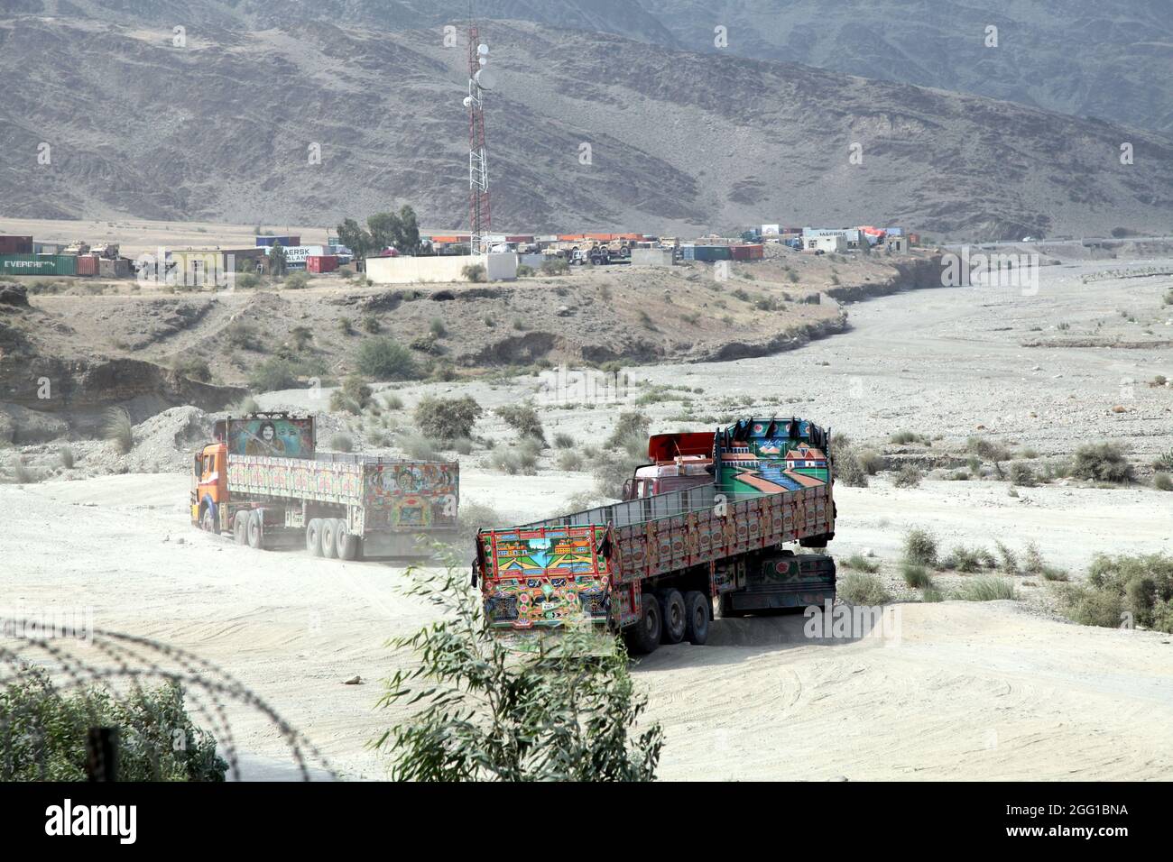 Jingle-Lastwagen manövrieren zur Inspektion außerhalb der Vorwärtsoperationsbasis Torkham in der Provinz Nangarhar, 9. September 2013. Die Hauptversorgungsroute ist für den Gütertransport durch das Torkham-Tor, in und aus Afghanistan und Pakistan vorgesehen. (USA Foto der Armee von Staff Sgt. Darian George/Freigegeben) Stockfoto