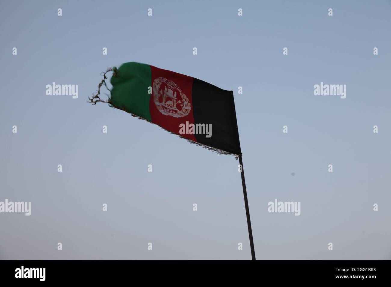 Eine zerfetzte afghanische Flagge weht über dem Khyber Joint Border Coordination Center auf der Forward Operation Base Torkham in der Provinz Nangarhar, Afghanistan, 9. September 2013. (USA Foto der Armee von Staff Sgt. Darian George/Freigegeben) Stockfoto