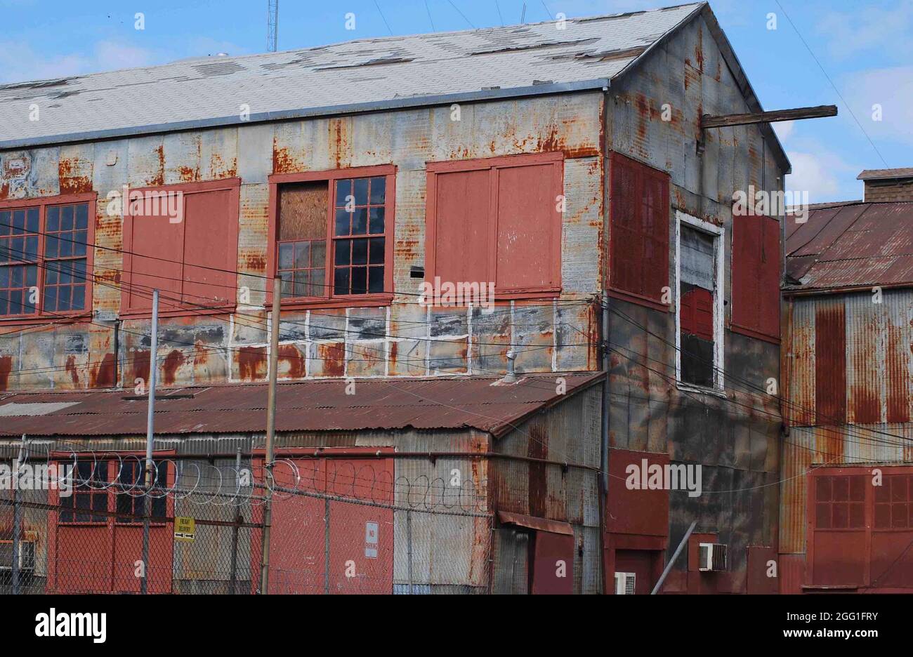 Eine baufällige Fabrik verfällt in einer kleinen Stadt in Kalifornien, da Rost zum dominierenden Farbton wird. Stockfoto