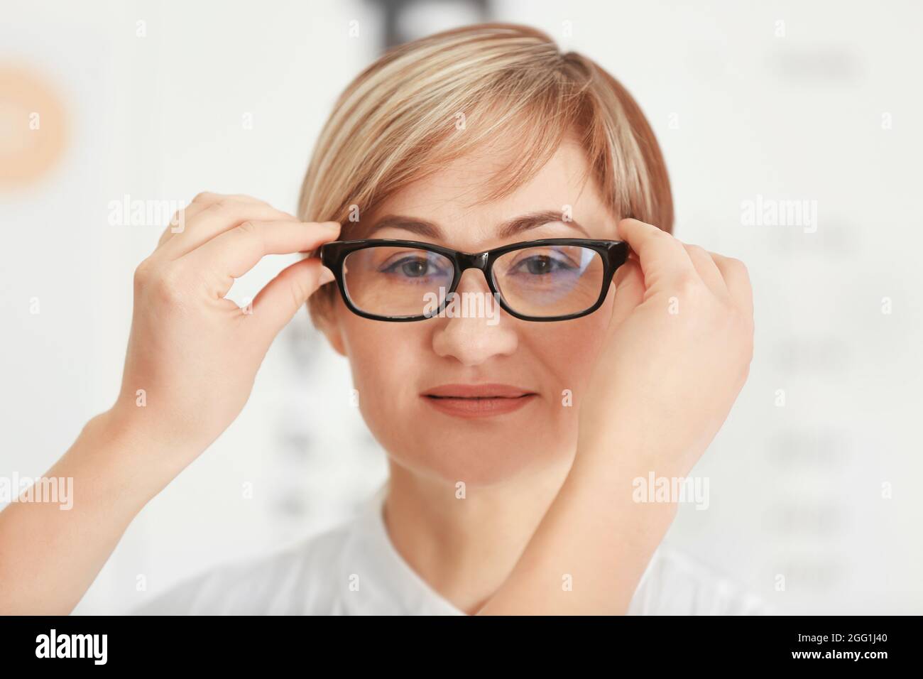 Die Hände der weiblichen Augenarzt, Brille auf der Nase, reife Frau in der Klinik