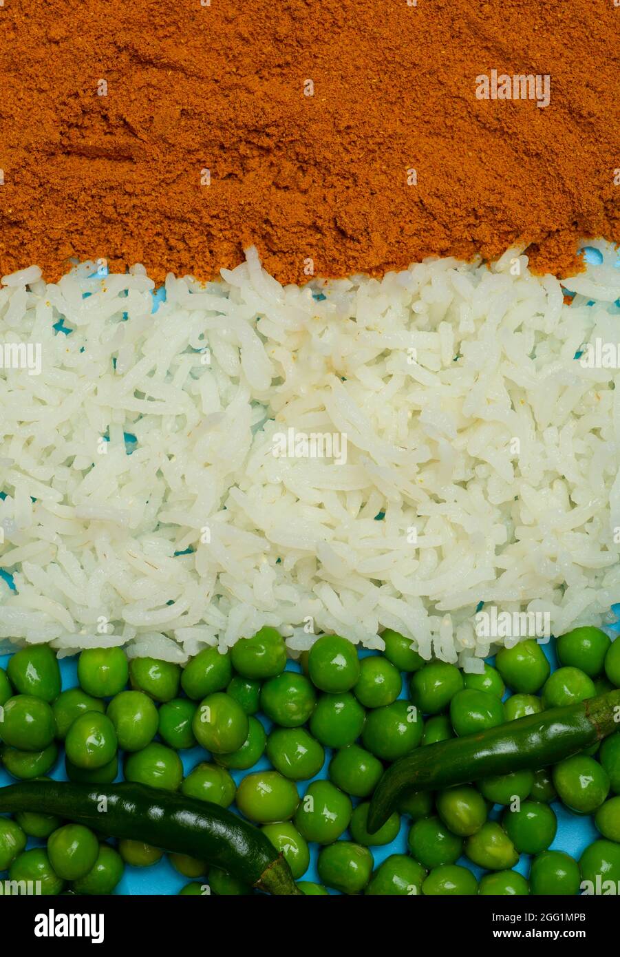 Indische Flagge aus Lebensmittelhintergrund. Basmati-Reis, Paprika, grüne Erbsen und Chilischoten in den Farben der indischen Flagge auf blauem Hintergrund. Hochwertige Fotos Stockfoto