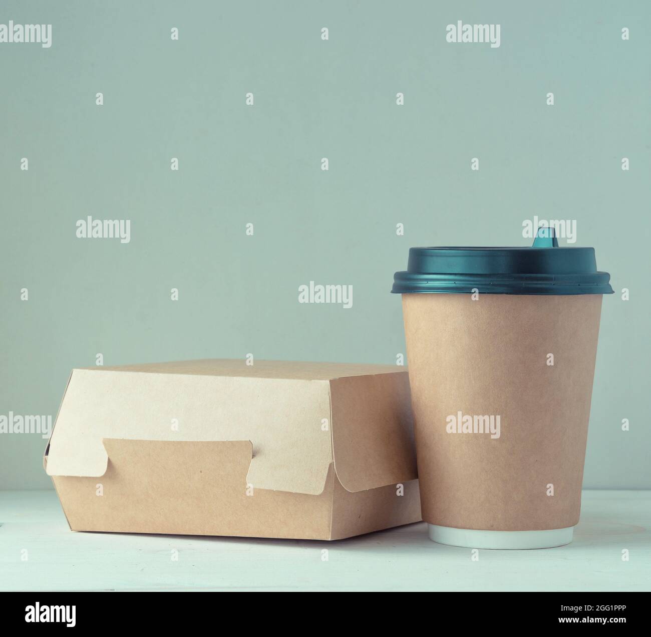 Kaffeetasse aus Papier und Lebensmittelbox auf dem Tisch Stockfoto