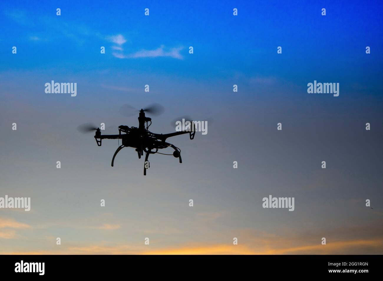 Wiederaufnahme einer Drohne zu vier Helixen im Flug im Moment des Sonnenuntergangs Stockfoto
