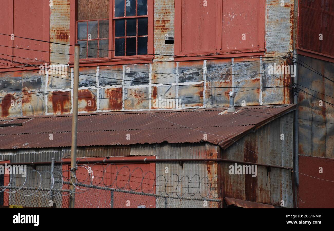 Eine baufällige Fabrik verfällt in einer kleinen Stadt in Kalifornien, da Rost zum dominierenden Farbton wird. Stockfoto
