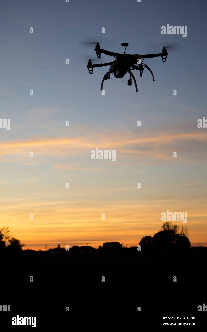Wiederaufnahme einer Drohne zu vier Helixen im Flug im Moment des Sonnenuntergangs Stockfoto
