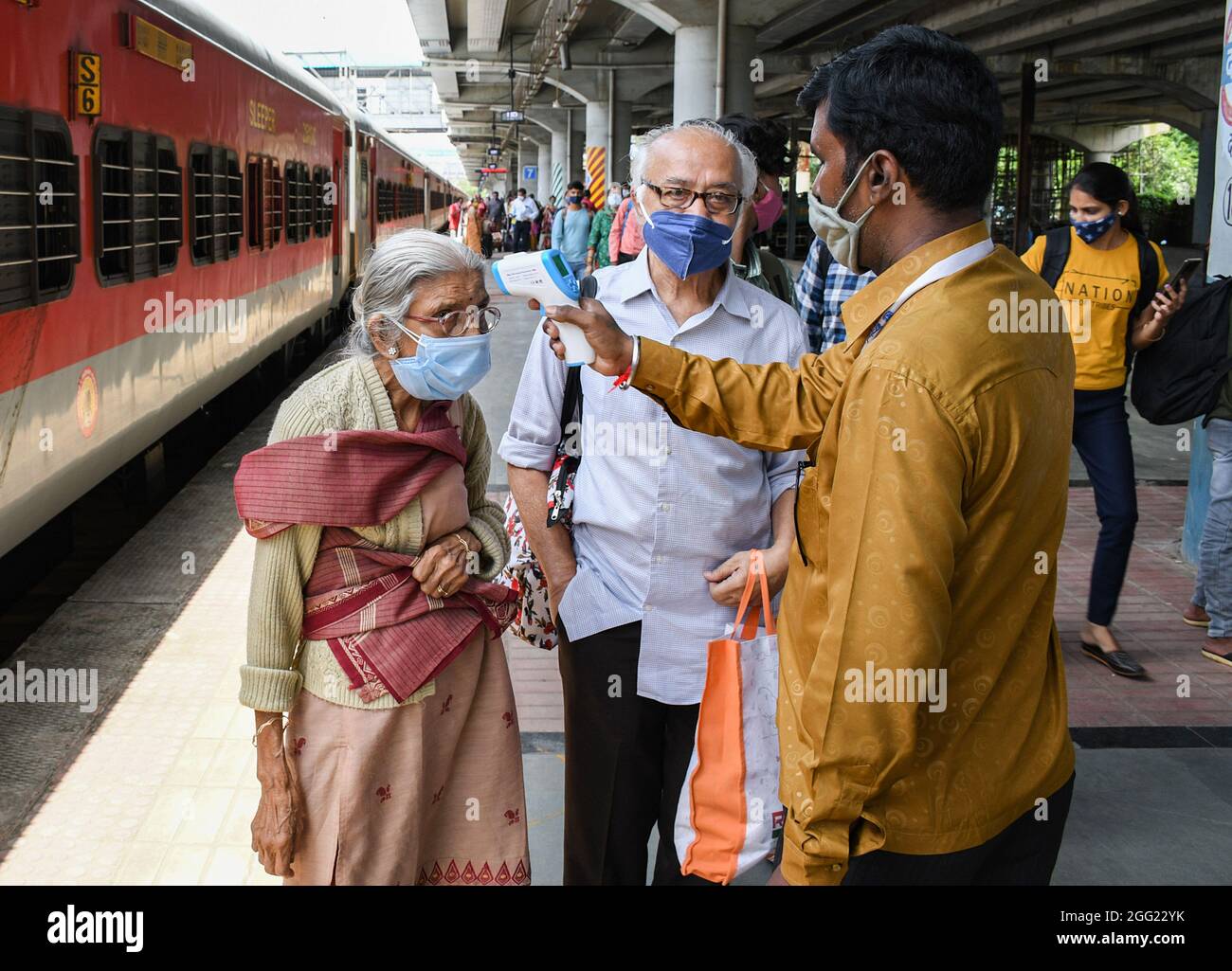 Mumbai, Indien. August 2021. Ein Mitarbeiter des Gesundheitswesens überprüft die Temperatur einer Frau am Dadar Terminus.Passagiere, die mit dem Außenbahnhof ankommen, müssen sich einer Temperaturkontrolle und in einigen Fällen einem RT-PCR-Test unterziehen, bevor sie zu ihrem jeweiligen Ziel fahren dürfen. (Foto von Ashish Vaishnav/SOPA Images/Sipa USA) Quelle: SIPA USA/Alamy Live News Stockfoto