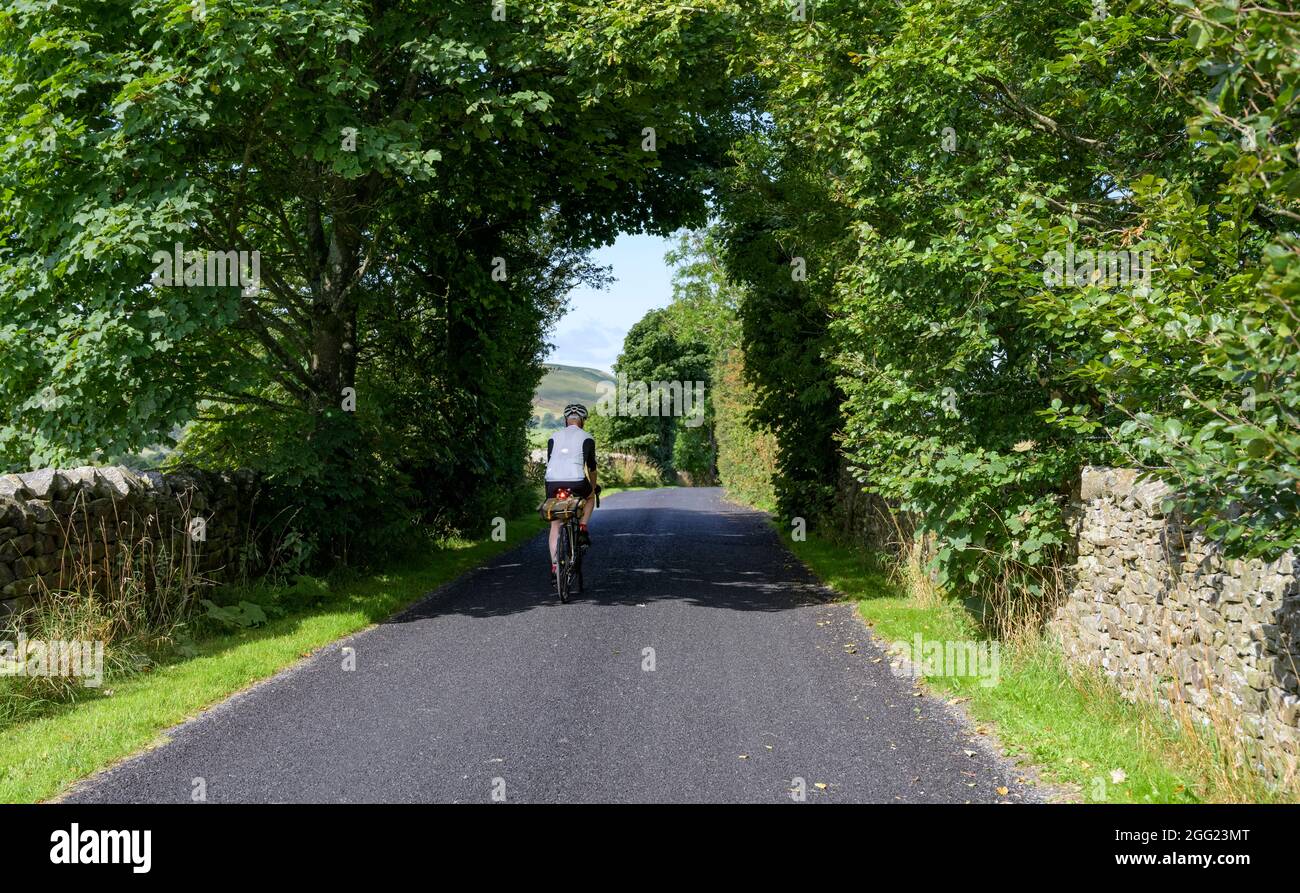 Männlicher Radfahrer auf ruhiger Fahrspur nach Harrop Fold aus Holden, Bowland, Lancashire, Großbritannien. Stockfoto