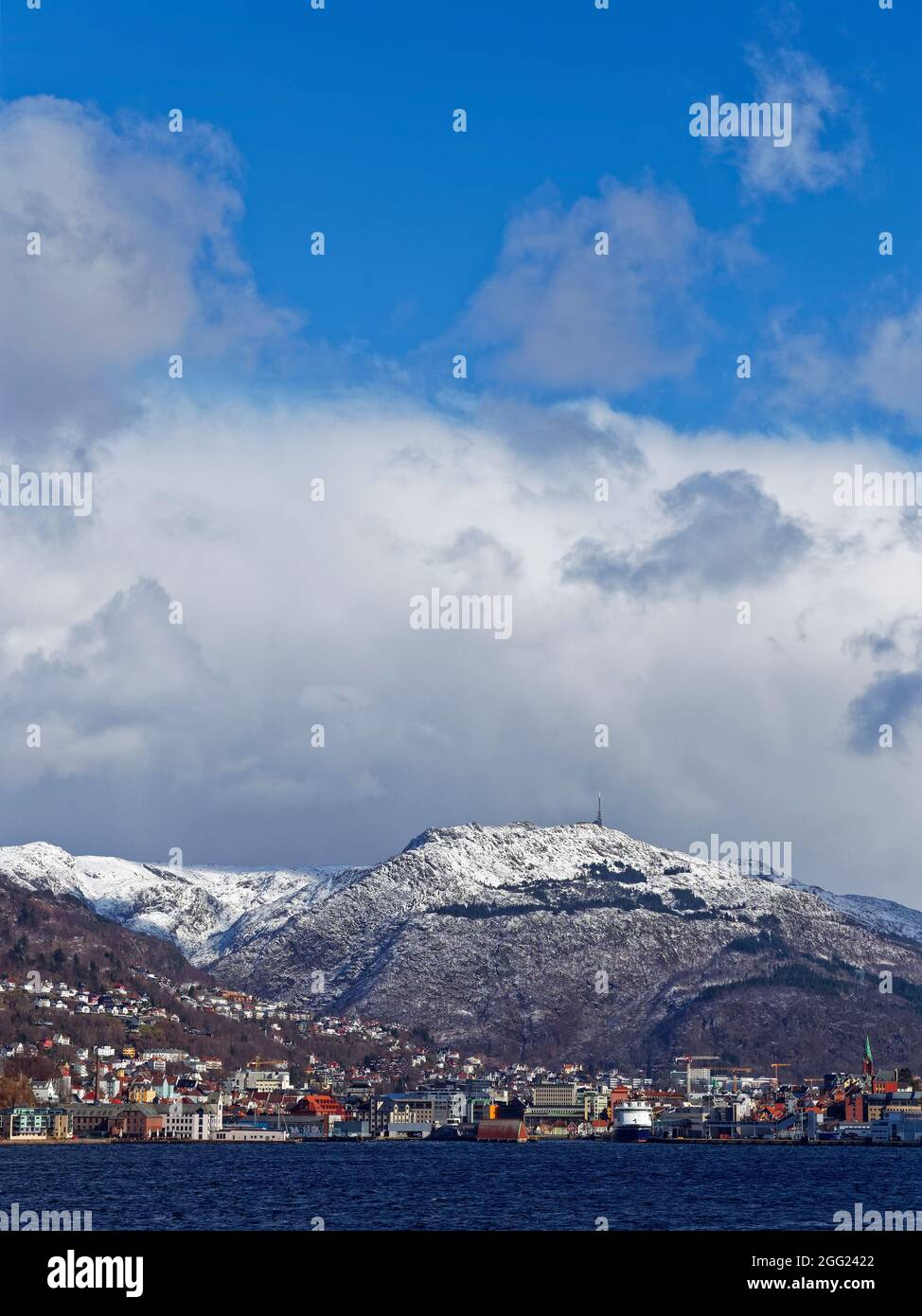Der Kommunikationsturm auf dem Gipfel des Ulriken mit Blick auf Bergen an einem winterlichen Tag im April. Stockfoto