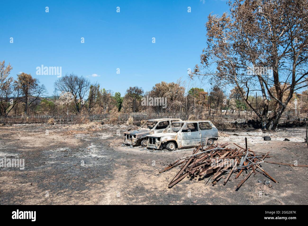 Zerstörte Fahrzeuge, die bei einem Gärtner gesehen wurden, dessen Material und Kultur von Olivenbäumen während der Zeit danach völlig verbrannt wurden. Das Feuer, das am 17. August 2021 in der Plaine des Maures (Var) ausging, brannte mehr als 7,100 Hektar Wald ab. Zwei Menschen wurden tot aufgefunden. Der Schaden für die Wirtschaftstätigkeit wird noch bewertet. Stockfoto