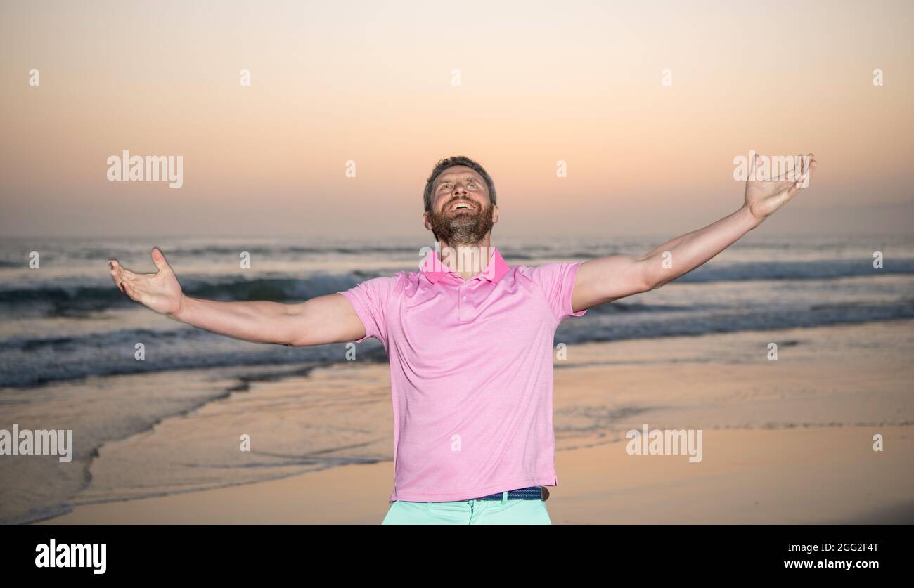Glücklicher Mann über dem Meer fühlen Freiheit am Morgen Sommer Strand, Urlaub Stockfoto
