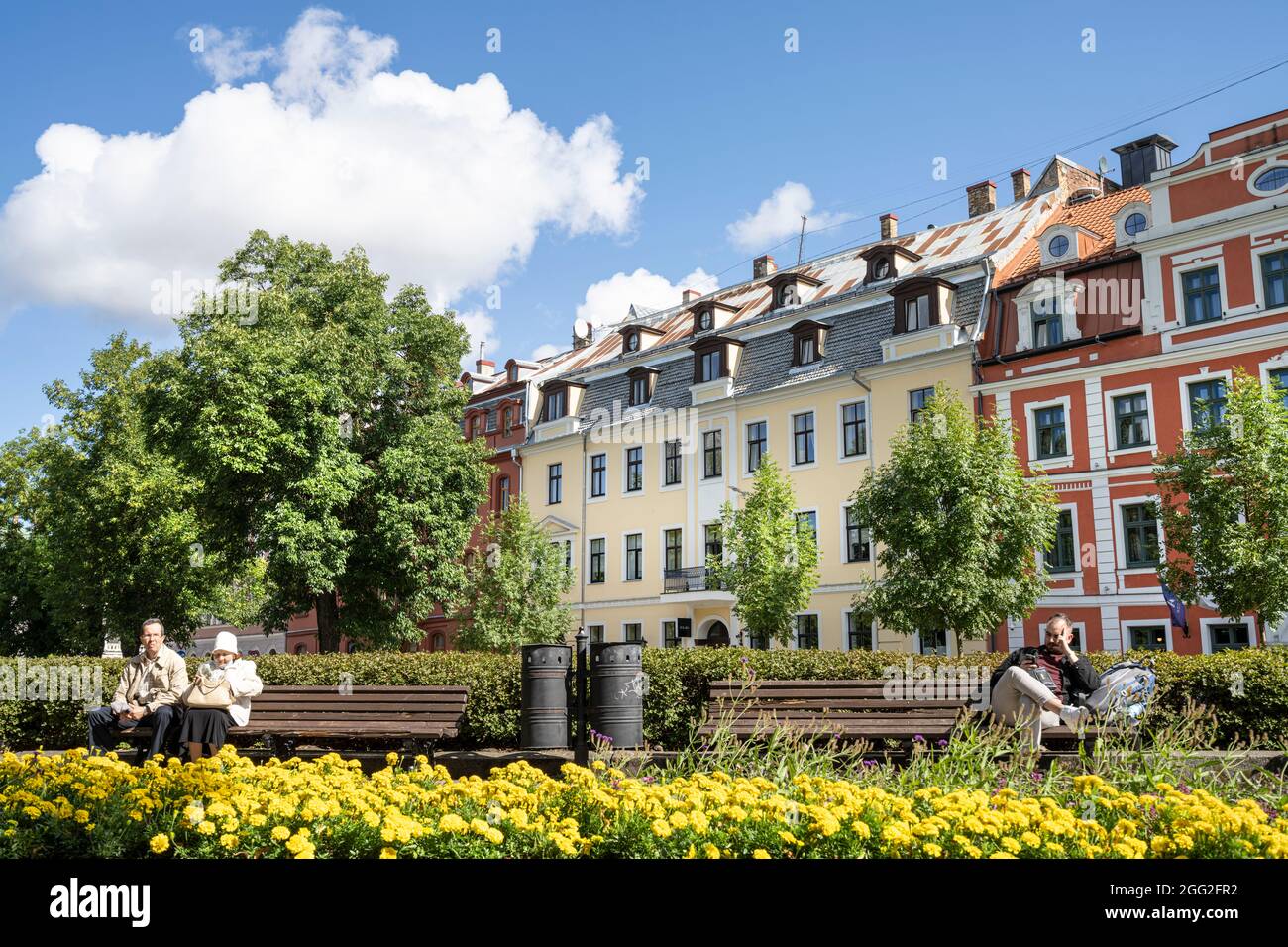 Riga, Lettland. 22. August 2021. Einige Leute sitzen auf den Bänken in einem Park im Zentrum der Stadt Stockfoto