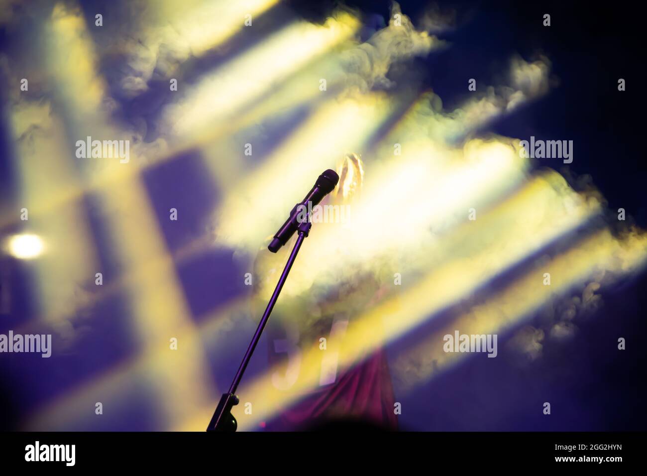 Mikrofon in Bühnenbeleuchtung mit farbigen Scheinwerfern und Rauch. Konzert- und Theaterszene Stockfoto