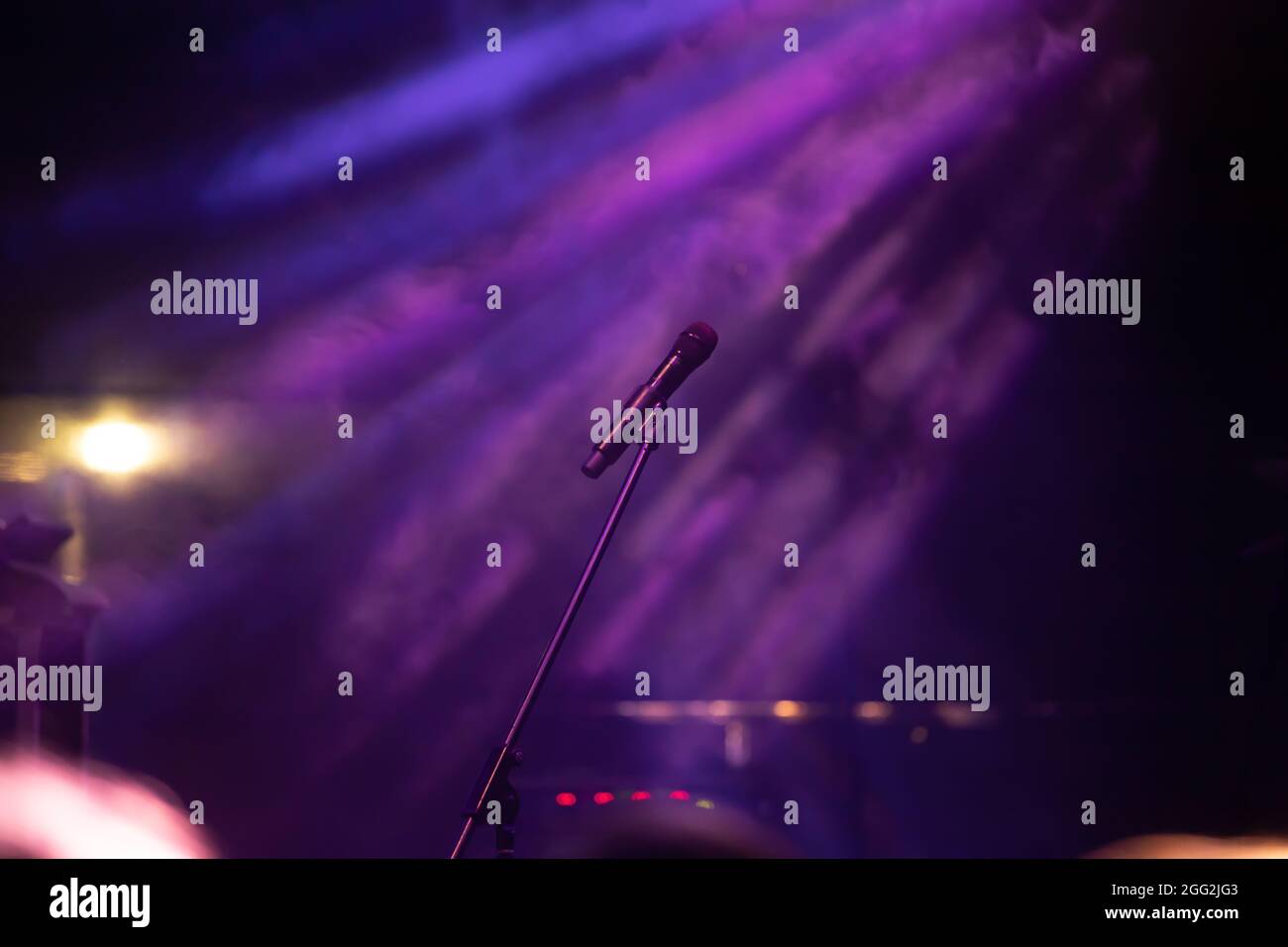 Mikrofon in Bühnenbeleuchtung mit farbigen Scheinwerfern und Rauch. Konzert- und Theaterszene Stockfoto