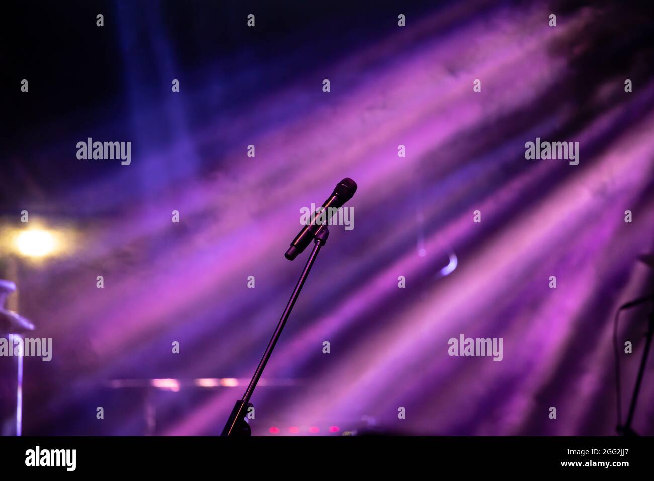 Mikrofon in Bühnenbeleuchtung mit farbigen Scheinwerfern und Rauch. Konzert- und Theaterszene Stockfoto