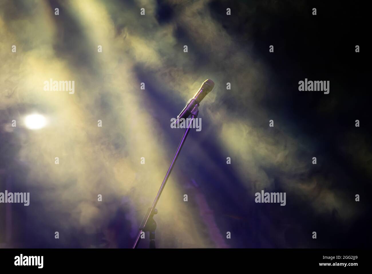 Mikrofon in Bühnenbeleuchtung mit farbigen Scheinwerfern und Rauch. Konzert- und Theaterszene Stockfoto