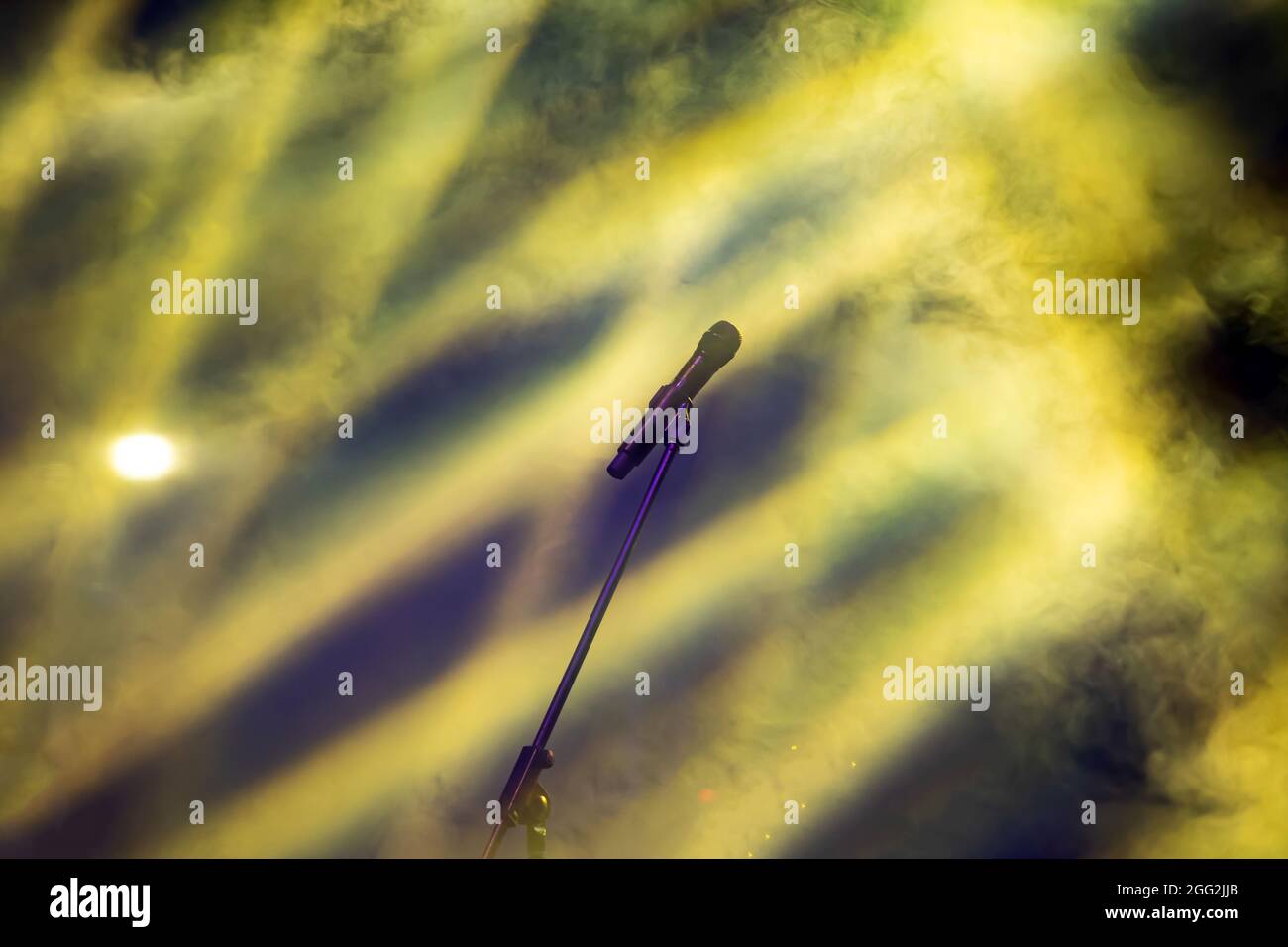 Mikrofon in Bühnenbeleuchtung mit farbigen Scheinwerfern und Rauch. Konzert- und Theaterszene Stockfoto