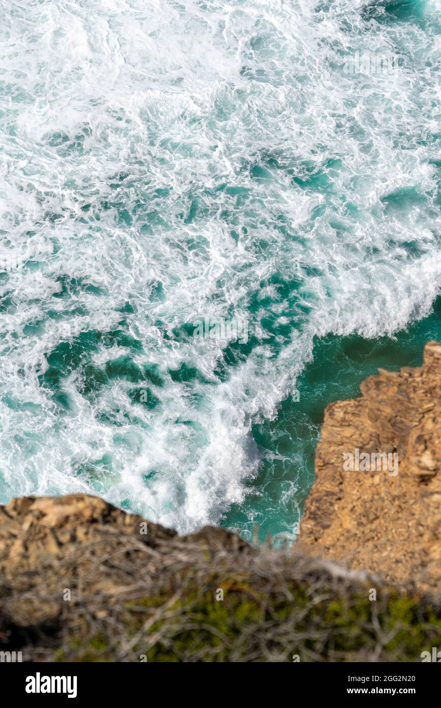 Meereswellen und Blick auf den Strand. Blauer Wasserhintergrund. Meerblick von oben. Strand am Atlantik mit Sandtextur Tapete, Poster Stockfoto