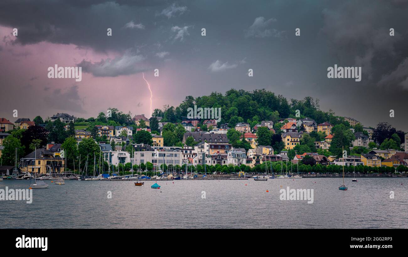 Gewitter über eine Stadt auf dem See, Blick auf die Stadt und Boote im See warten auf den kommenden Sturm Stockfoto