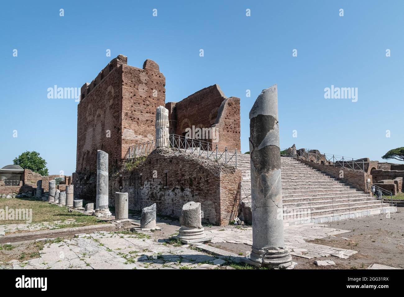 Das capitolium bei archäologischen Ausgrabungen von Ostia Antica von Ruinen, Säulen und Statuen und Reliefs umgeben Stockfoto