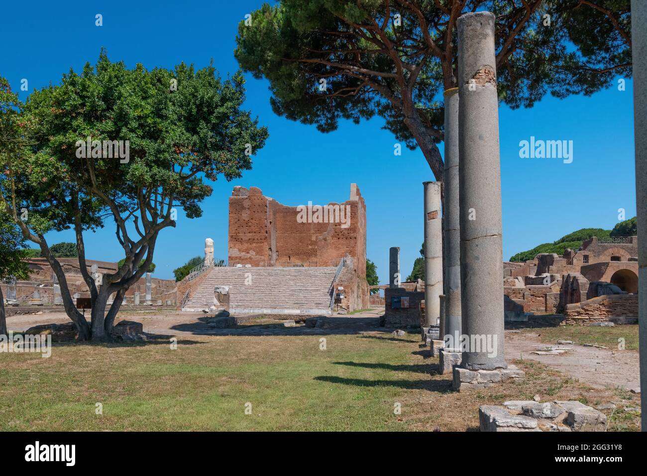 Das capitolium bei archäologischen Ausgrabungen von Ostia Antica von Ruinen, Säulen und Statuen und Reliefs umgeben Stockfoto