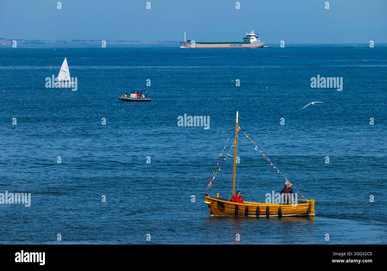 North Berwick, East Lothian, Schottland, Großbritannien, 28. August 2021. UK Wetter: Wassersport. Im Bild: Boote aller Art an einem sonnigen Tag im Firth of Forth mit einem Frachtschiff in der Ferne am Horizont Stockfoto