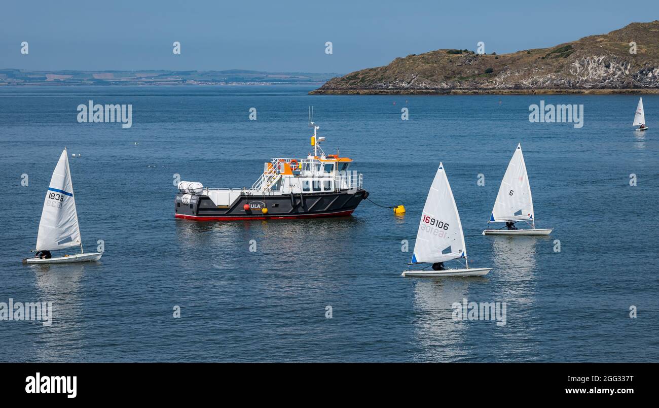 North Berwick, East Lothian, Schottland, Großbritannien, 28. August 2021. UK Wetter: Wassersport. Im Bild: Segelboote aus dem East Lothian Yacht Club fuhren an einem sonnigen Tag in den Firth of Forth zu einer Segelregatta Stockfoto