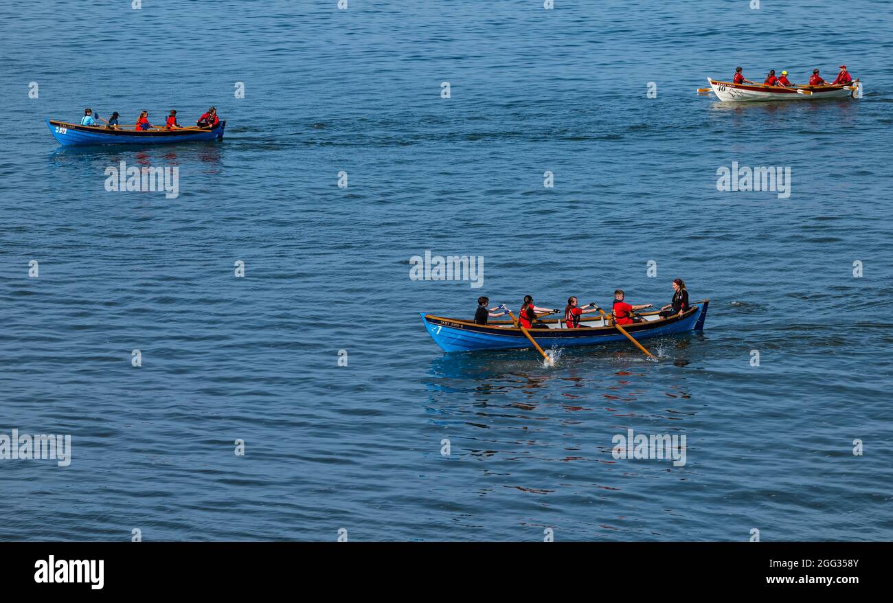 North Berwick, East Lothian, Schottland, Großbritannien, 28. August 2021. UK Wetter: Wassersport. Die Küstenstadt ist voll mit Menschen, die an einem sonnigen und heißen Feiertagswochenende das Meer und Wassersport genießen. Im Bild: Crews aus den Ruderclubs an der Küste treten bei einer Regatta an Stockfoto