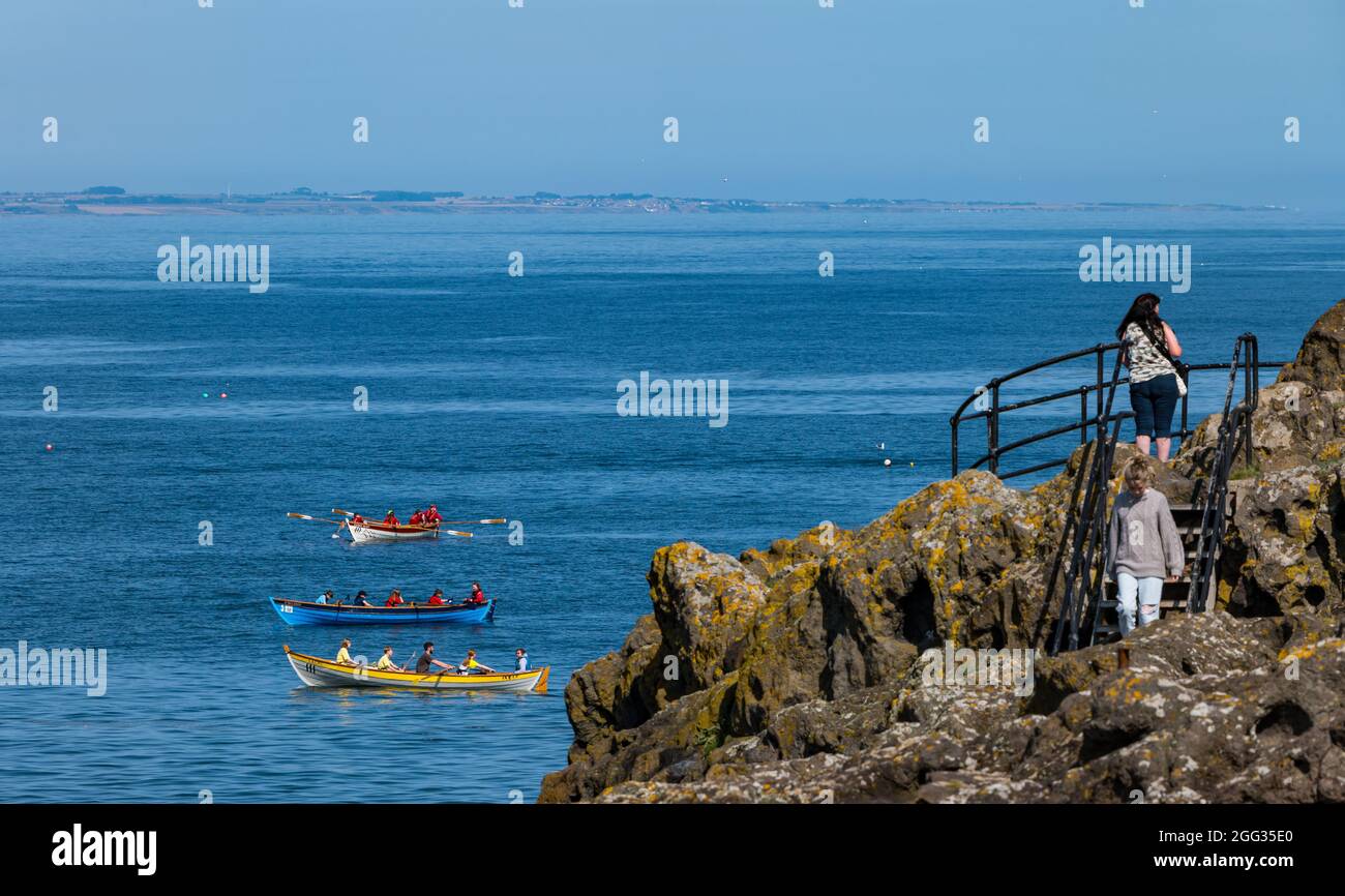 North Berwick, East Lothian, Schottland, Großbritannien, 28. August 2021. UK Wetter: Wassersport. Die Küstenstadt ist voll mit Menschen, die an einem sonnigen und heißen Feiertagswochenende das Meer und Wassersport genießen. Im Bild: Crews aus den Ruderclubs an der Küste treten bei einer Regatta an Stockfoto