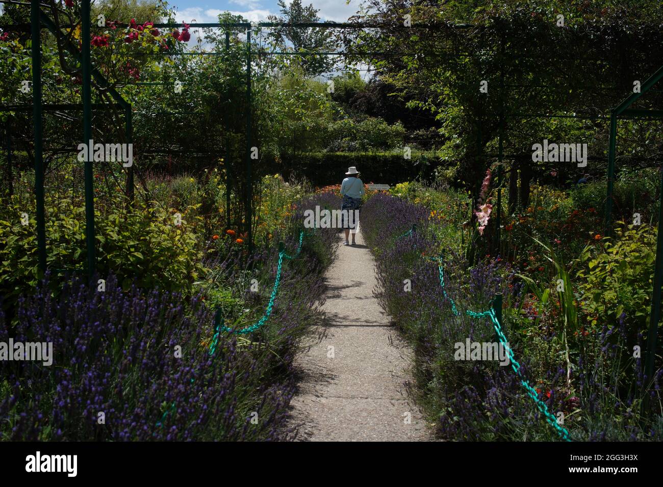 Frau auf dem Weg des Gartens von Claude Monet (Fondation Claude Monet), Giverny, Normandie, Frankreich Stockfoto