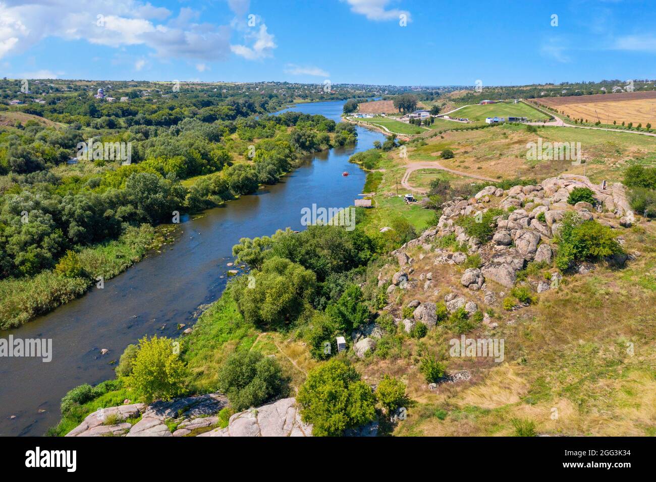 Ein wunderbarer Panoramablick von einer Drohne auf die Biegung des Southern Bug River mit Steinbänken und dichtem Grün an einem warmen Sommertag. Stockfoto