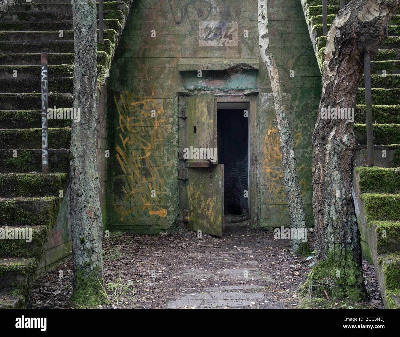 Offene Stahltür eines verlassenen Militärbunkers aus Beton in Hel, Polen. Der zweite Weltkrieg und die Artillerie-Festung aus dem Kalten Krieg, die in der Mitte auseinander fällt Stockfoto