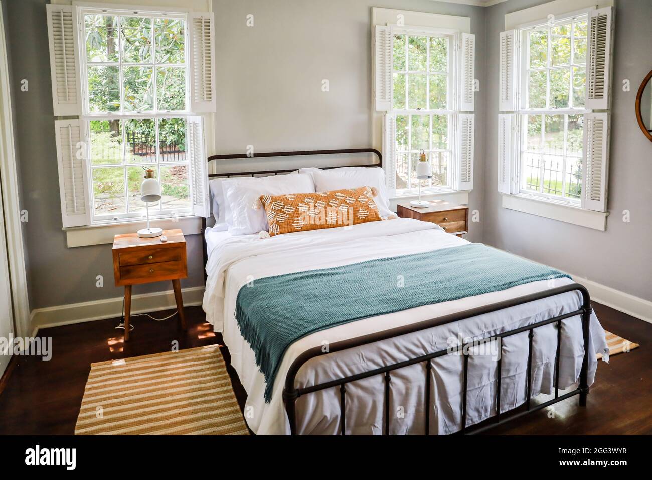 Ein Gästeschlafzimmer mit einem Queen-Size-Bett und Nachttisch in einem kurzfristigen Miethaus im Cottage-Stil Stockfoto