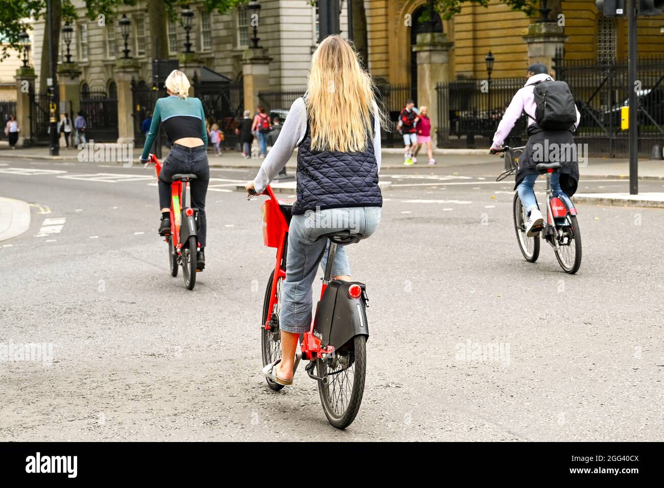 London, England - 2021. August: Menschen, die auf einer Straße mit Elektrofahrrädern fahren. Die Fahrräder können im Lime Bike-Fahrradverleihsystem ausgeliehen werden Stockfoto