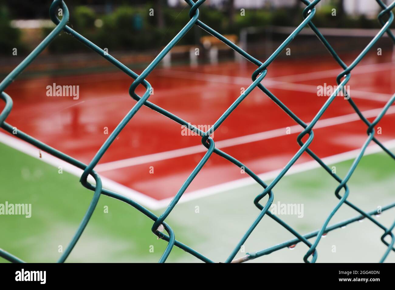 Tennisplatz hinter Zaun mit Fokus auf den Vordergrund. Stockfoto