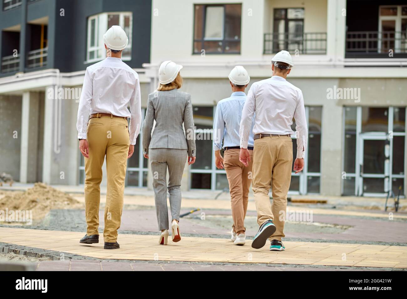 Elegante Baumanagerin und ihre Kollegen, die den Gebäudebereich inspizieren Stockfoto