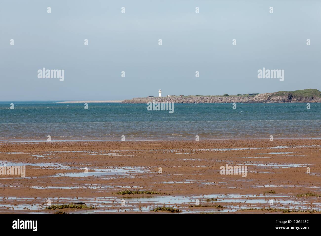 Eine Teleansicht des Hodbarrow Lighthouse gegenüber der Duddon-Mündung von Dunnerholme Stockfoto