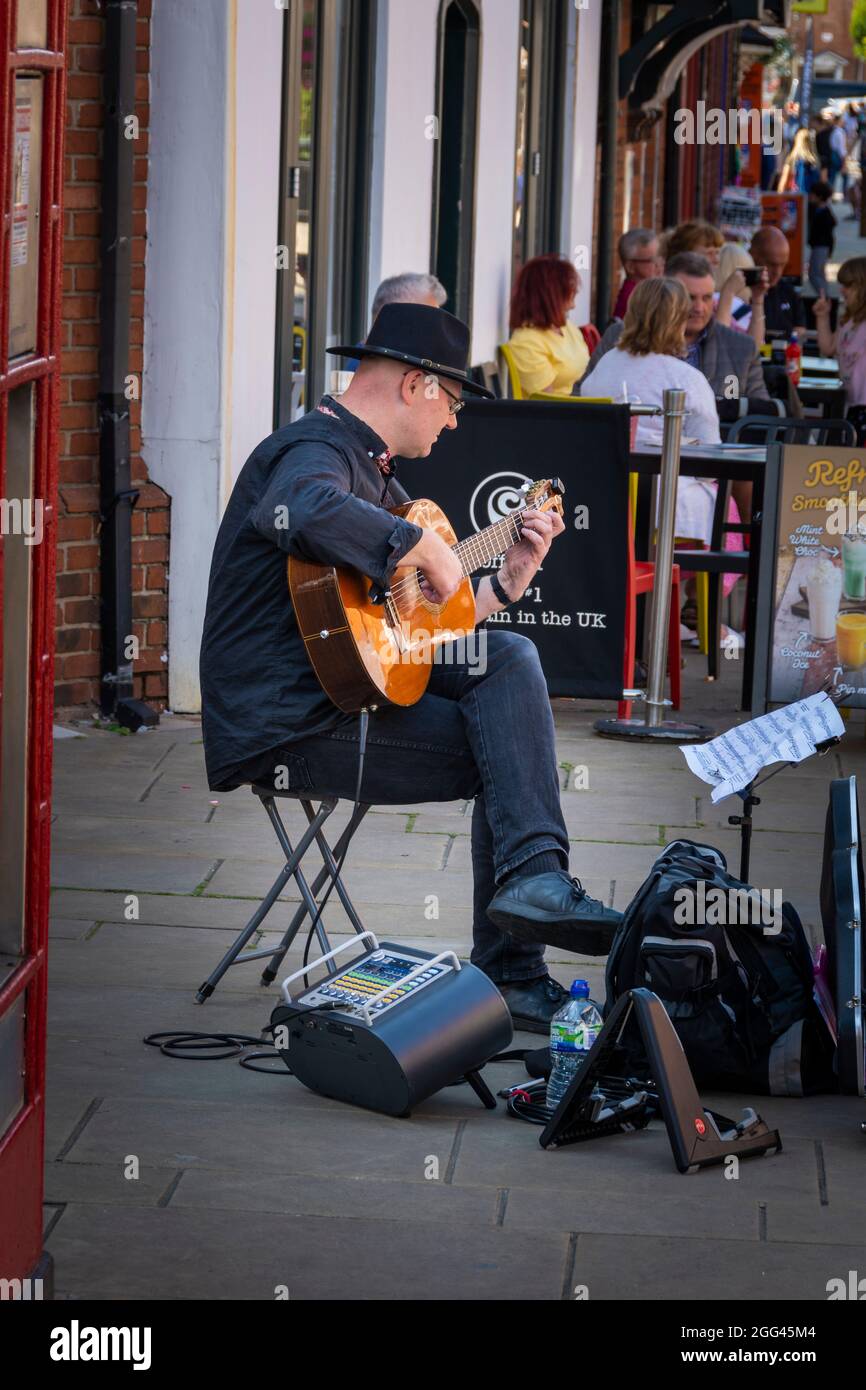 Straßenmusiker spielt Gitarre im Zentrum von Stratford-upon-Avon. Stockfoto