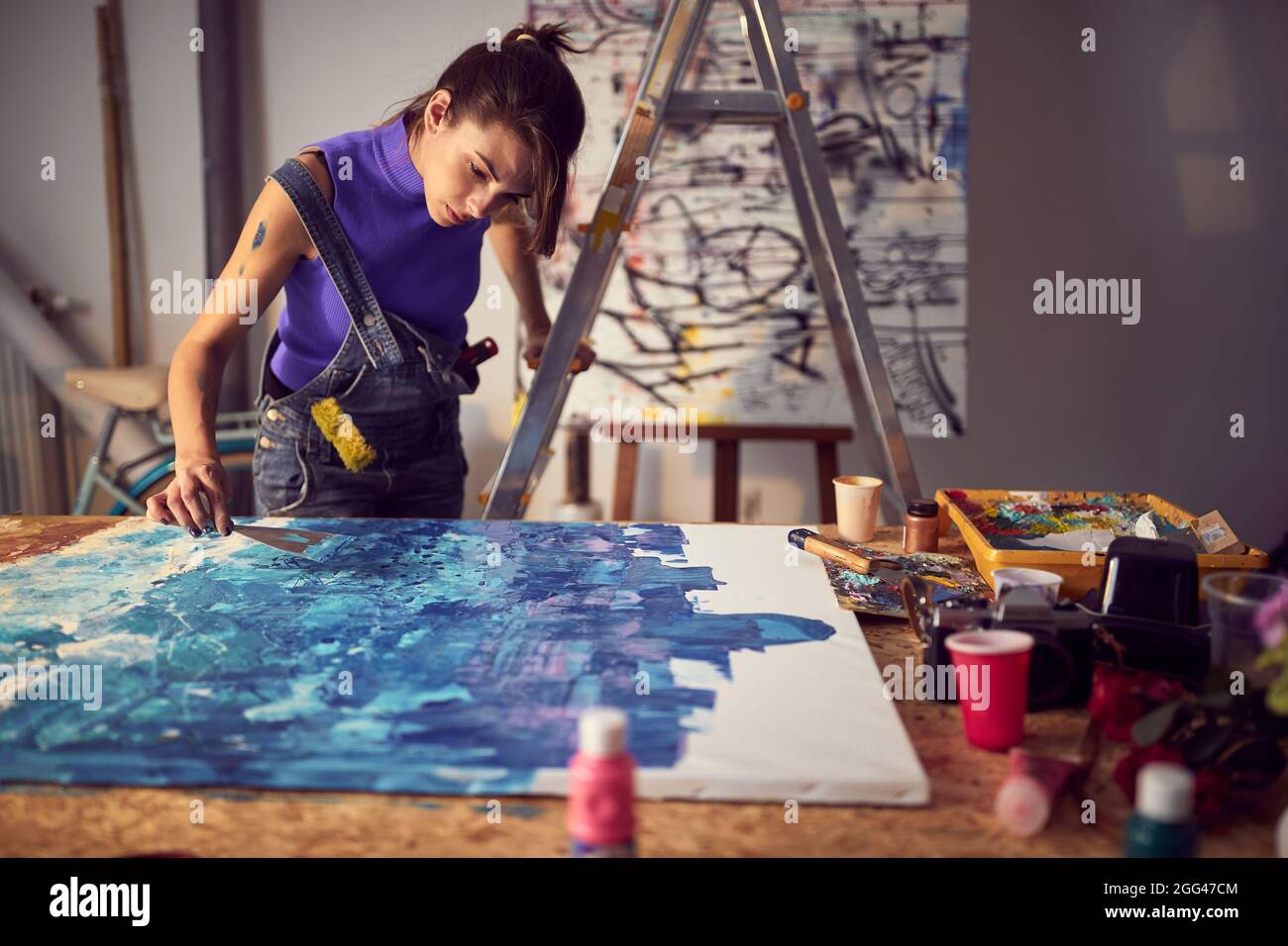 Fokussierte Malerin, die im Atelier ein neues Werk schuf Stockfoto