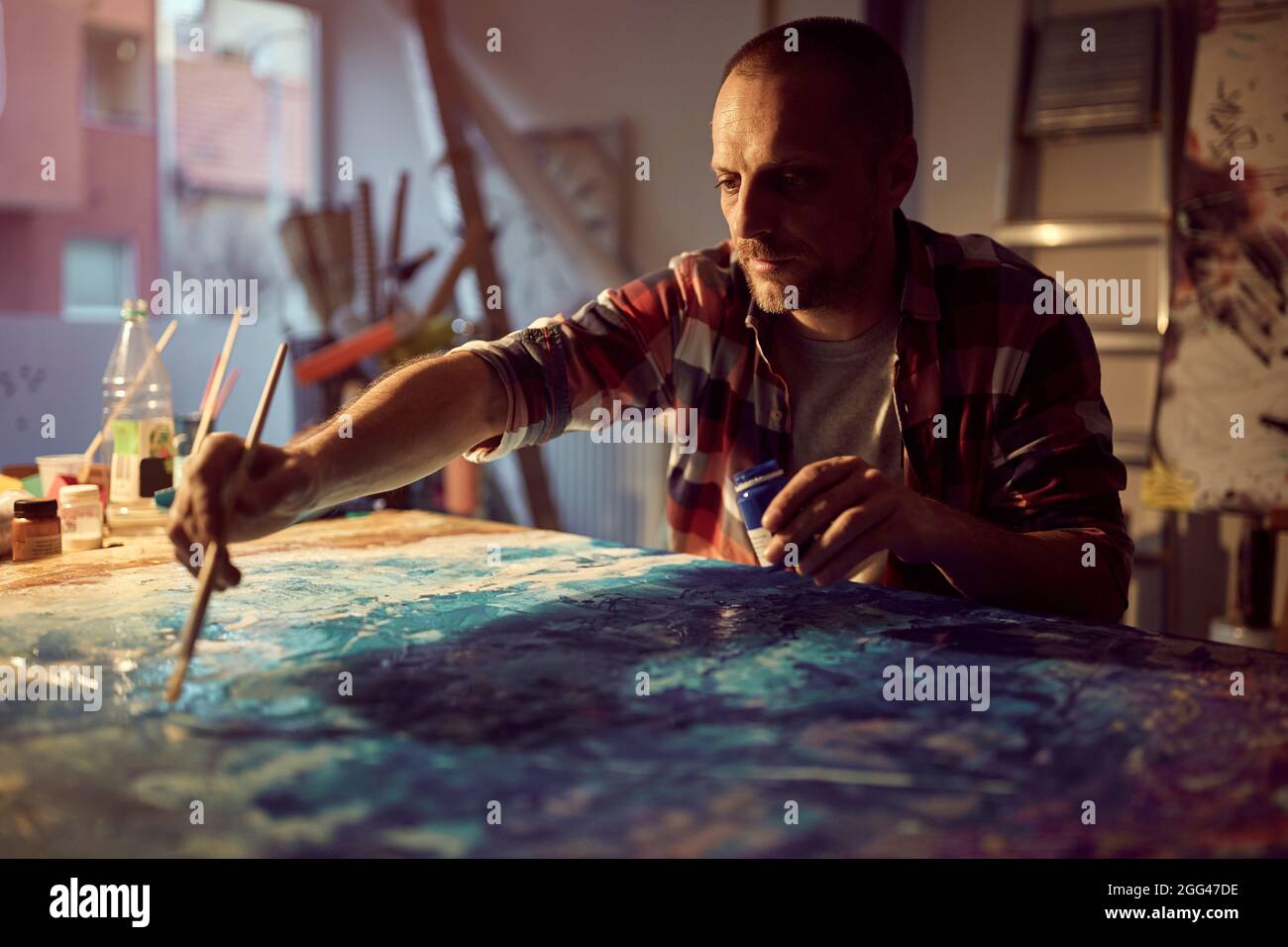 Kaukasischer Malerkünstler, der im Atelier ein neues Werk schuf Stockfoto