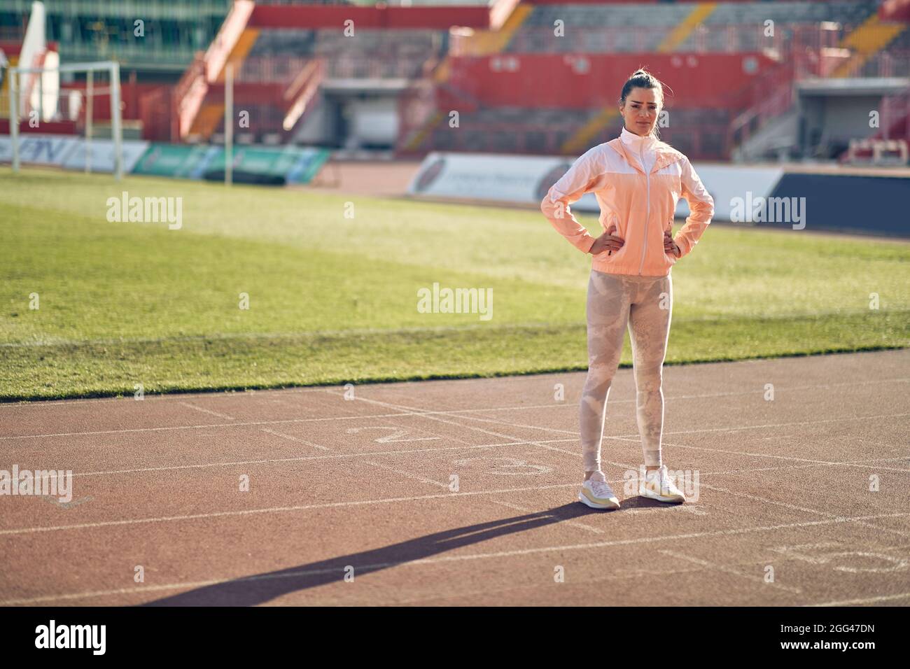 Profi-Läufer steht auf der Strecke.lächelnde Joggerin in Sportswear. Stockfoto