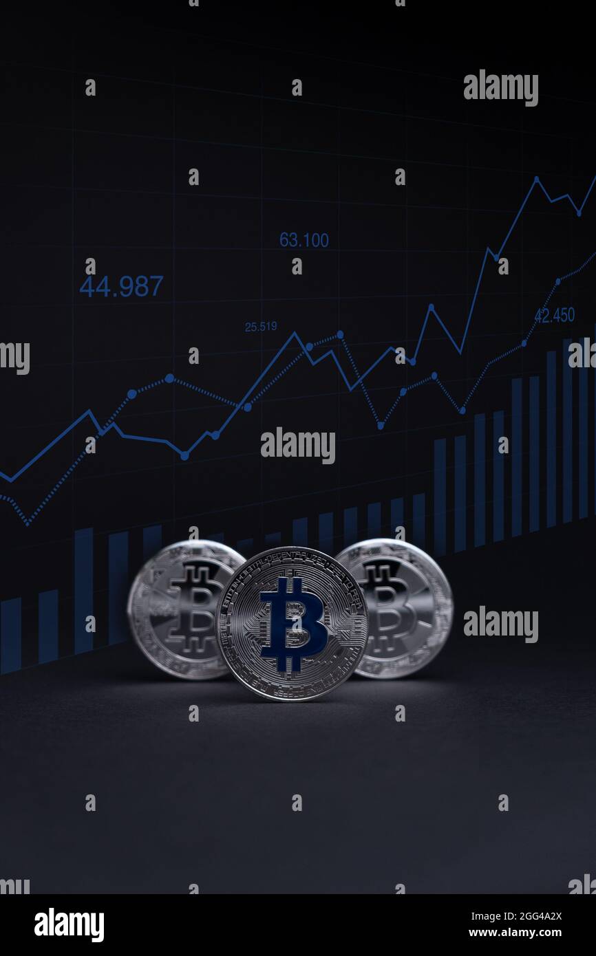 Silber Bitcoin Münzen Währung. Krypto-Münze mit Wachstumskarte, auf dunklem Hintergrund. BTC International Stock Exchange. Stockfoto