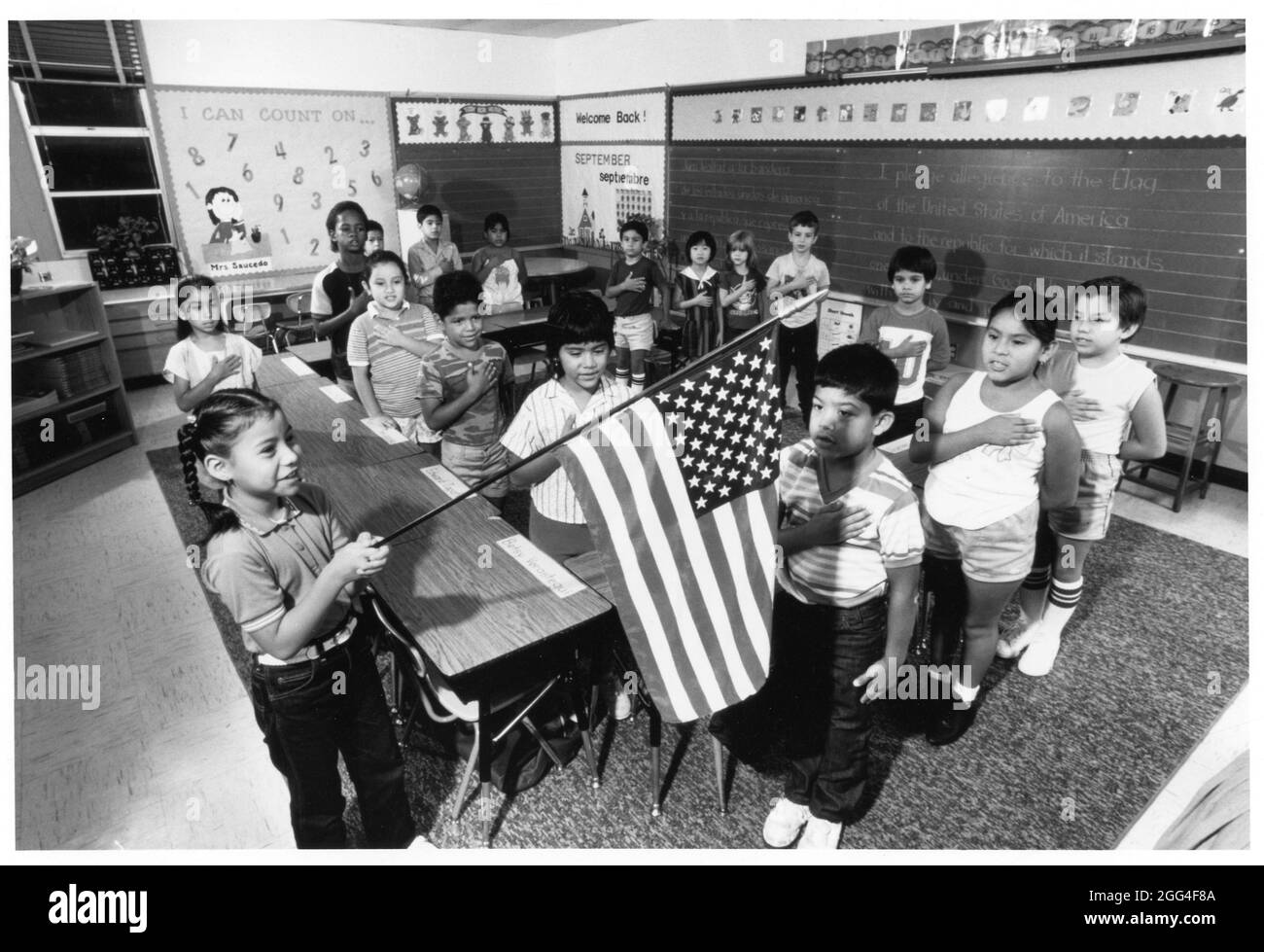 Austin Texas USA, um 1988: Zweitklässler, die in ihrem Klassenzimmer das Versprechen der Treue zur Flagge der Vereinigten Staaten sagten. ©Bob Daemmrich Stockfoto