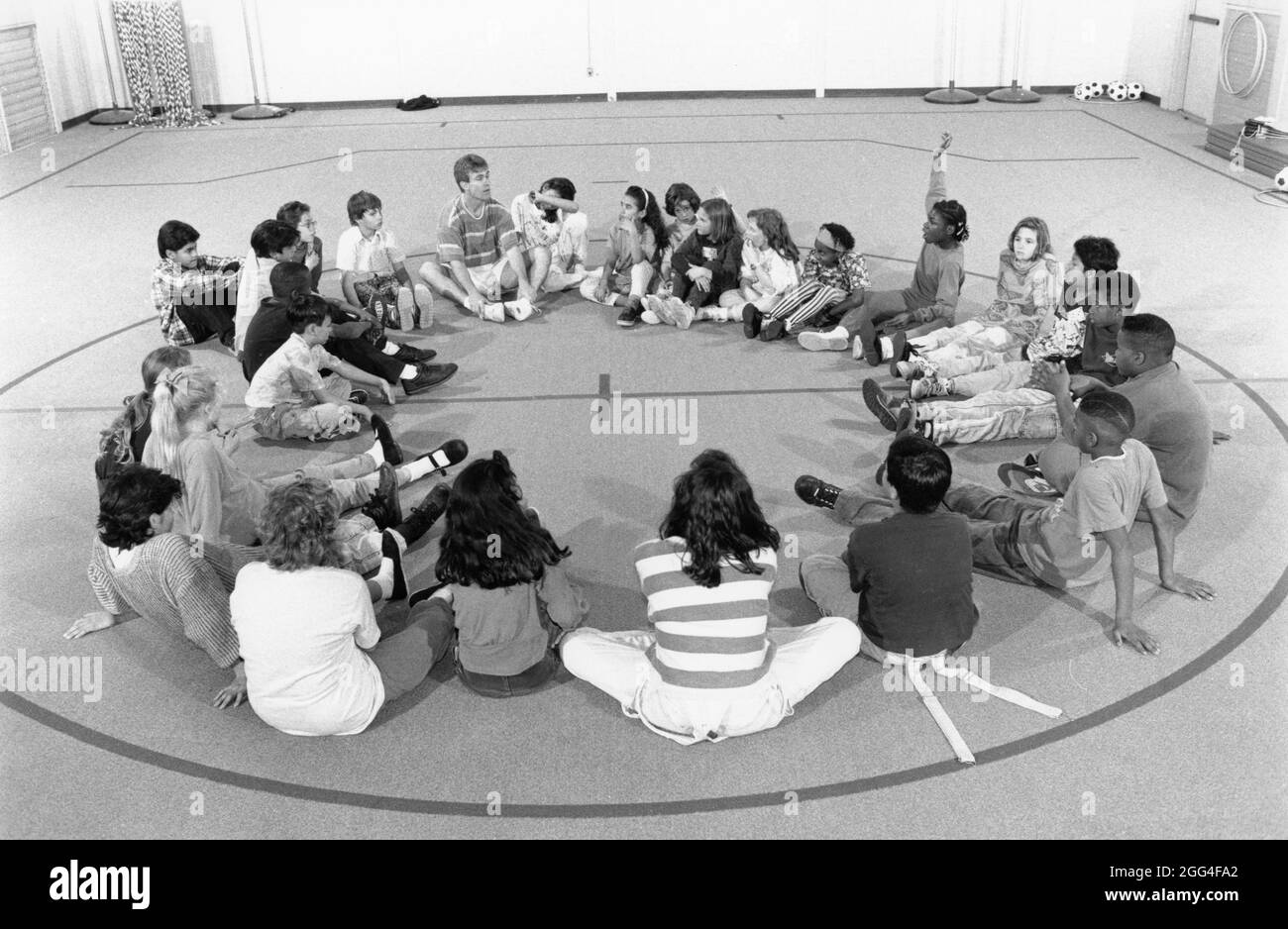 Austin Texas USA, um 1992: Studenten sitzen im Kreis auf dem Boden des Fitnessraums während der Diskussion in der Klasse für Sportunterricht an der Walnut Creek Elementary School. , EH-0206 ©Bob Daemmrich Stockfoto
