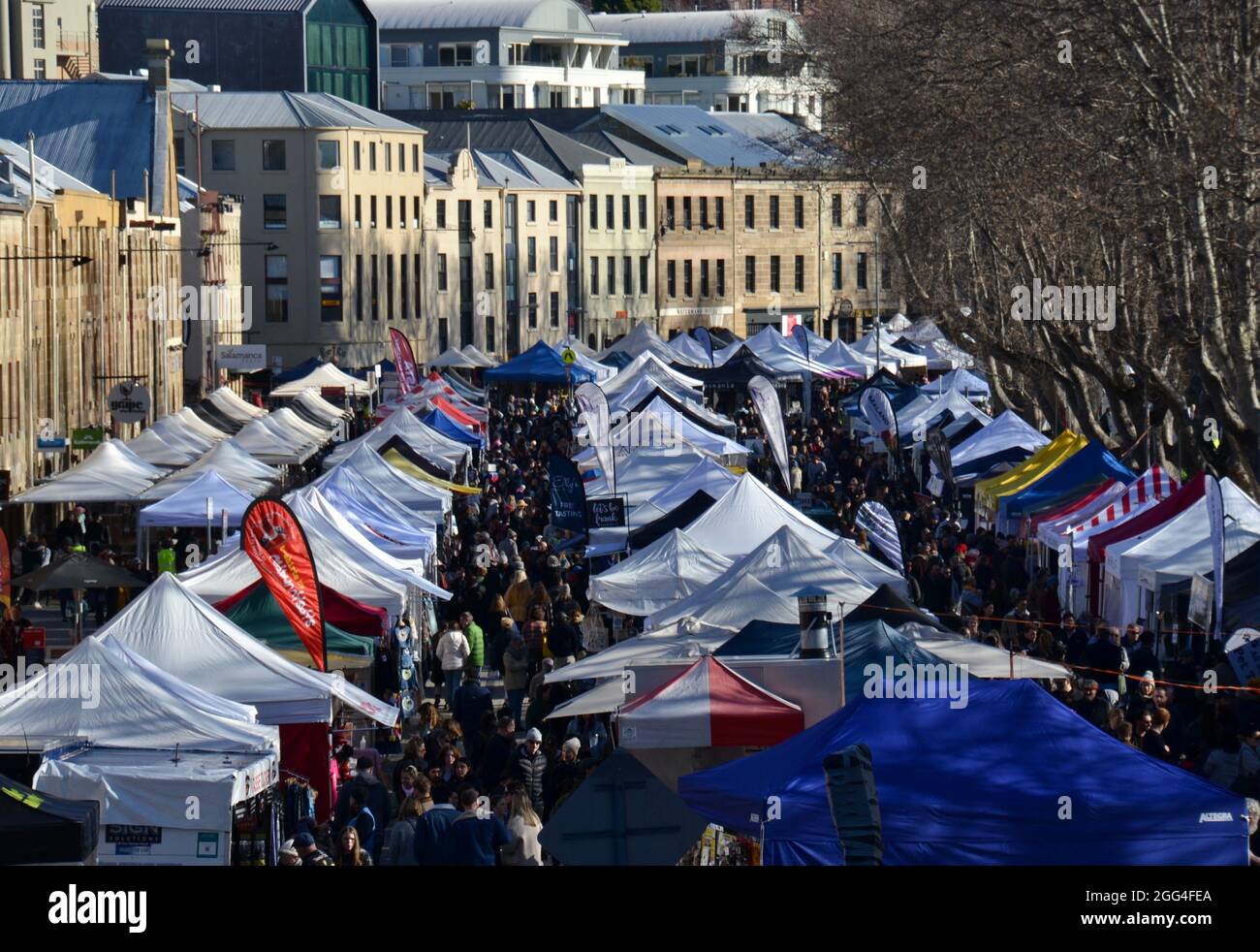 Geschäftigen Wintermorgen auf dem Salamanca Market in Hobart mit Ständen für Kunst und Kunsthandwerk, Speisen und Produkte und einer großen Menschenmenge von Einkäufern Stockfoto