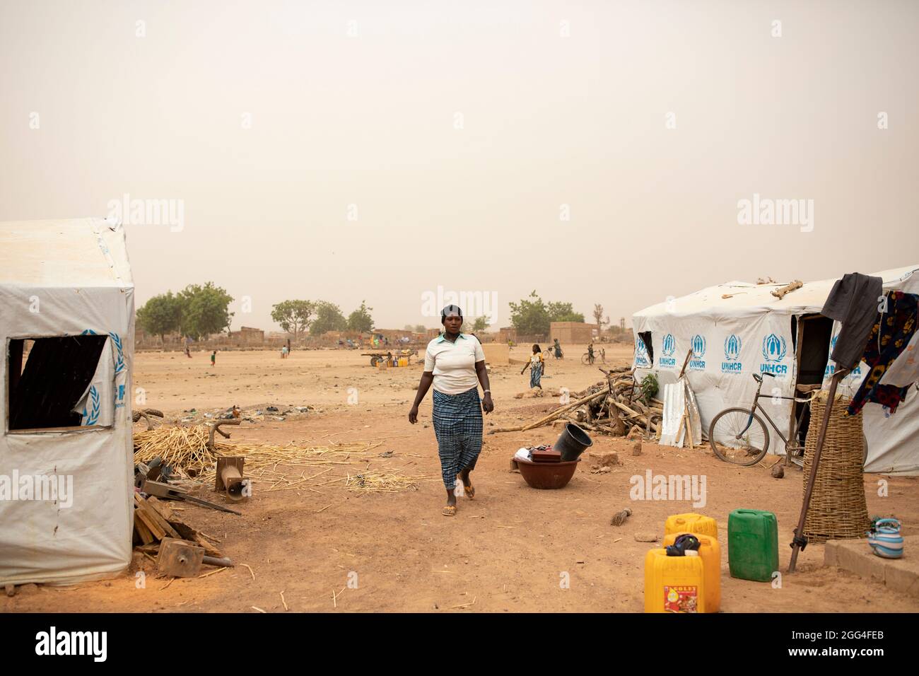 Sawadogo Ramata (33) und ihre Großfamilie flohen vor Gewalt und Unsicherheit, um sich außerhalb der Stadt Nouna, Burkina Faso, zu beherbergen. Heute leben mehr als 30 von ihnen in einem Gelände aus gemieteten Zimmern und provisorischen Zelten, die vom UNHCR bereitgestellt werden. Da sie keine Möglichkeit haben, zu bewirtschaften, steht die Familie vor Hunger und Lebensmittelknappheit. Krise In Der Sahelzone 2021; Provinz Kossi, Burkina Faso. Februar 18, 2021. Foto von Jake Lyell. Stockfoto