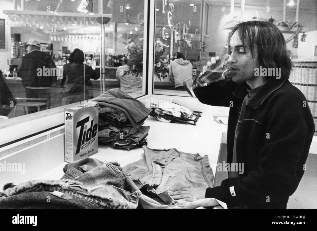 Austin Texas USA, um 1983: Der Mäzen des Unternehmens „Barwash“ macht seine Wäsche, während er ein Glas Bier genießt. ©Bob Daemmrich Stockfoto