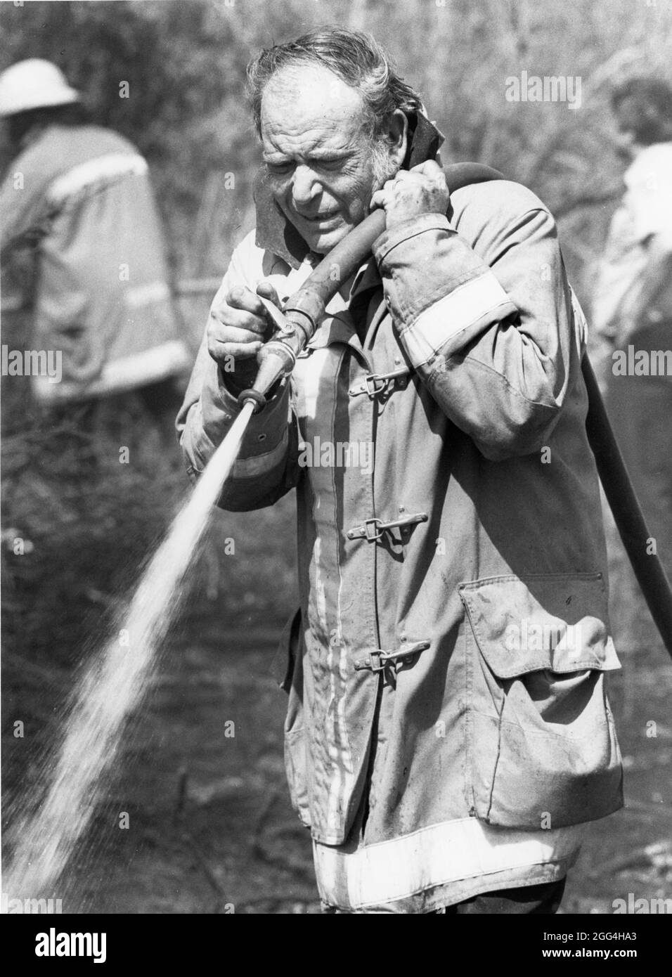 1990: Mitglied der Freiwilligen Feuerwehr hilft bei der Löschung von Grasbränden im ländlichen Raum. ©Bob Daemmrich Stockfoto