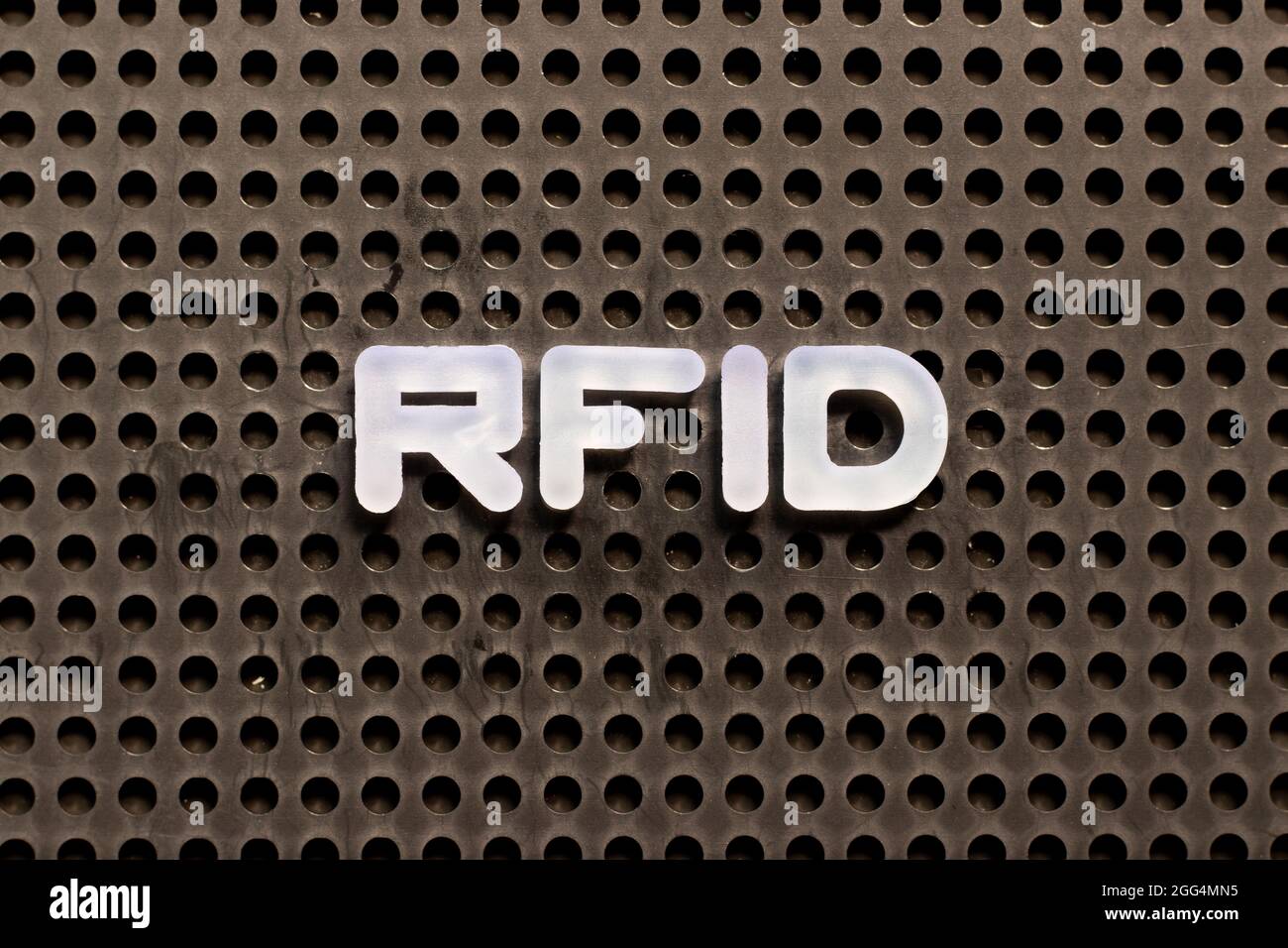 Weißer Buchstabe im Wort RFID (Abkürzung für Radio-frequency identification) auf schwarzem Hintergrund der Leiterplatte Stockfoto